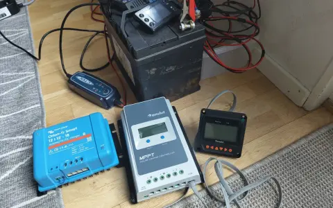 En batteriladdare och solcellsregulatorer kopplade till ett batteri. Var försiktig, ett kokande batteri är farligt.
