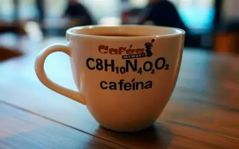 Taza de café blanca con la fórmula química de la cafeína y el texto "cafeína" impresos.