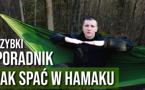 Mężczyzna w lesie pokazuje, jak prawidłowo wykonać mocowanie hamaka, by wygodnie spać w naturze.