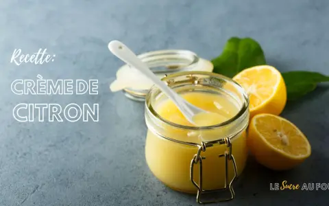 Une recette de crème au citron rapide, prête à être dégustée. Un pot en verre rempli de cette crème onctueuse, avec des citrons frais et des feuilles vertes.