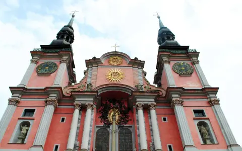 Święta Lipka: barokowa bazylika z zegarami na wieżach i złotymi symbolami religijnymi. Atrakcje tego miejsca przyciągają turystów.