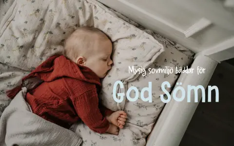 Sött barn sover i spjälsäng, inbäddat i mjukt tyg med blommor. En mysig sovplats som bäddar för god sömn.