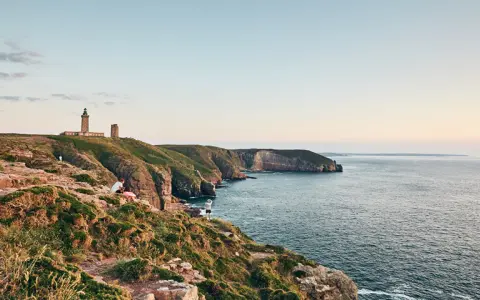 Vue panoramique sur le Cap Fréhel, avec son phare emblématique et les falaises bretonnes. Parfait pour une randonnée sur le GR 34.