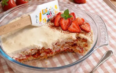 Un délicieux tiramisu fraise, garni de fruits frais et d'une touche de cacao, prêt à être dégusté.