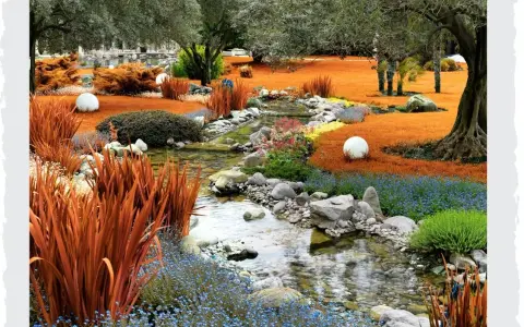 Ein malerischer asiatischer Garten mit einem Bachlauf, orangefarbenem Gras, blauem und gelbem Blütenteppich, Steinen und weißen Kugeln.