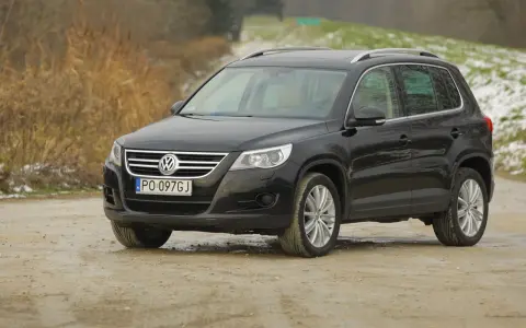 Czarny Volkswagen Tiguan, jeden z najmniej awaryjnych SUV-ów 10 letnich, na drodze gruntowej.