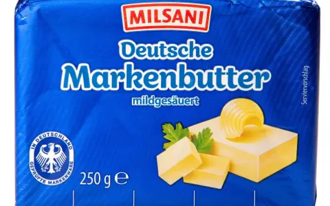 Milsani Deutsche Markenbutter, mildgesäuert. Ein Serviervorschlag zeigt drei Butterstücke und eine Butterrose auf einem Stück Butter.