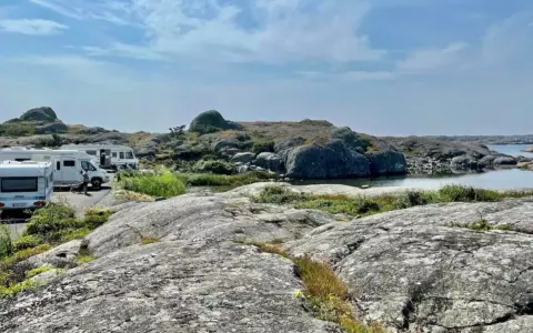 Husbilscamping vid en klippig kust, en perfekt plats för en **turista i Skåne** som söker lugn och natur.