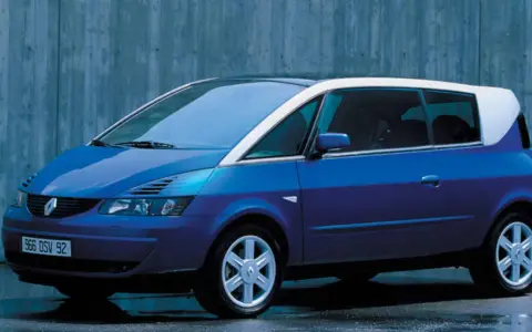 Niebieski Renault Avantime z białym dachem, stojący na tle betonowej ściany.