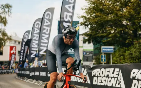 Fokus auf den Radfahrer beim rad wm zeitfahren. Er kämpft sich durch, die Garmin-Fahnen wehen im Hintergrund.