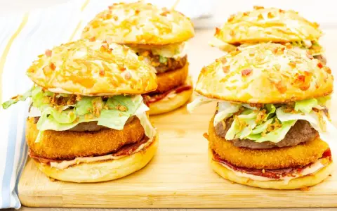 Pyszny burger drwala przepis: soczysty kotlet, chrupiąca panierka, świeża sałata i chrupiąca cebulka w bułce z bekonem.