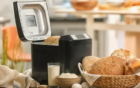 Machine à pain ouverte, avec du pain frais dans un panier. Avis sur la machine à pain : facile et pratique pour un pain maison.