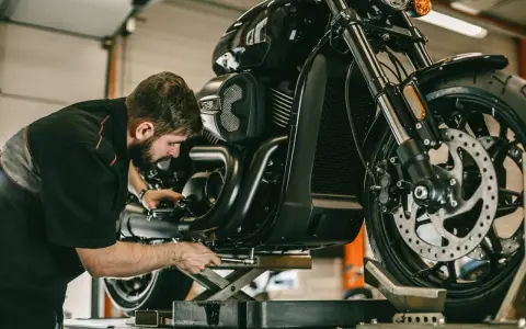 Meccanico al lavoro su una moto. Per sapere i tagliandi Ducati ogni quanti km, consulta il manuale.