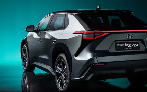 Tył samochodu Toyota bZ4X Concept na tle turkusowego tła.