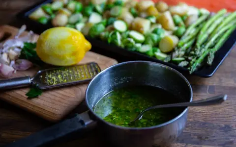 Förberedelser för allt på en plåt lax: färsk lax, potatis, brysselkål, sparris, citron och vitlök.