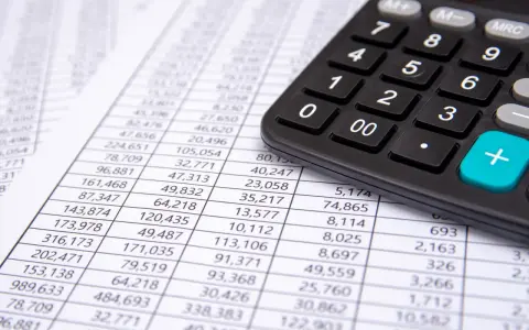 Calculadora sobre hoja de cuentas, mostrando posibles remuneraciones pendientes de pago activo o pasivo.