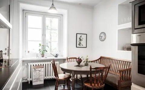 Mysig köksvrå med runt matbord, träbänk och stolar. Perfekt för runt matbord inspiration.