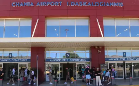 Människor med bagage anländer till Chania flygplats för sina avgångar.