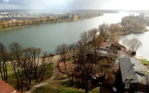 Malownicze jeziora w Kujawsko-Pomorskim, z drzewami w jesiennych barwach i miastem w tle.