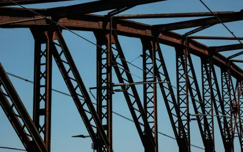 Estructura de puentes de hierro famosos contra el cielo azul. Cables cruzan la intrincada red de vigas oxidadas.