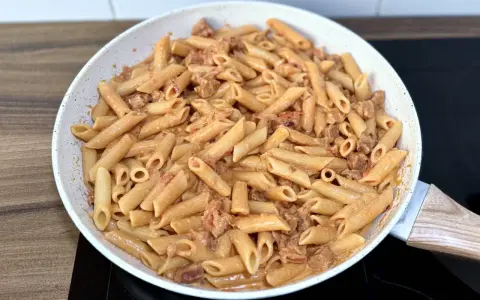 Penne z kremowym sosem i kawałkami pikantnego chorizo, gotowe do podania.