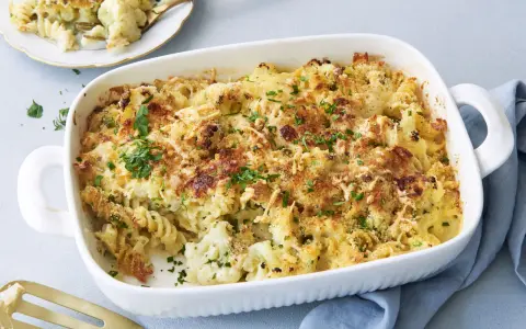 Ein goldbrauner blumenkohl nudel auflauf mit Käse überbacken und frischer Petersilie garniert, bereit zum Servieren.