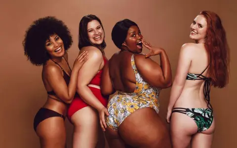 Fyra glada kvinnor i olika badkläder. En har en virkad bikini.