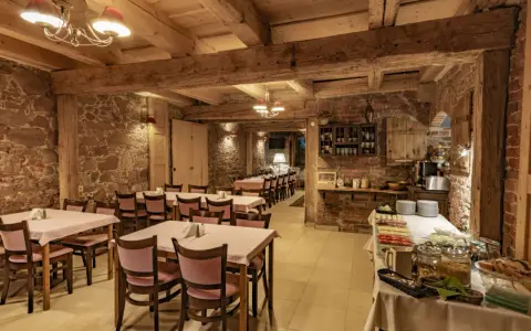 Przytulna restauracja w stylu rustykalnym, z kamiennymi ścianami i drewnianymi belkami. Idealne miejsce na posiłek w twierdzy Srebrna Góra.