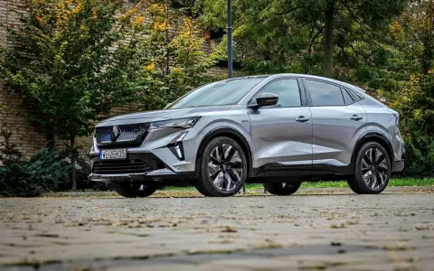 Nowy Renault Rafale, elegancki SUV coupe, prezentuje się na tle jesiennej zieleni i ceglanej ściany.