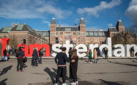 Ludzie pozują przy wielkich literach "I amsterdam" przed Rijksmuseum. Idealne miejsce na pamiątkowe zdjęcie z weekendu w Amsterdamie.