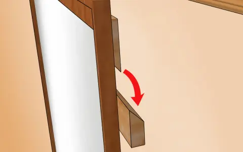 Instrucciones para colgar espejo: se muestra un soporte de madera que se desliza para asegurar el espejo.
