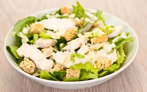Salade César appétissante avec poulet, croûtons dorés et copeaux de parmesan. Un classique des salade cesar ingredient.