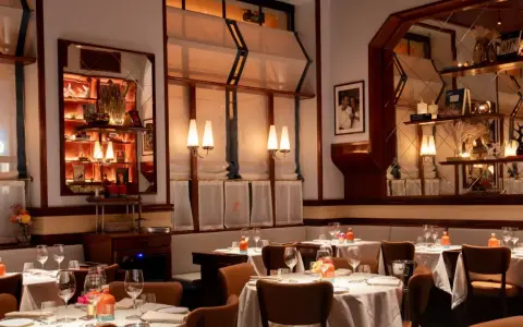 Tavoli apparecchiati in un ambiente elegante, ideale per scoprire i migliori ristoranti Milano. Luci soffuse e dettagli raffinati creano un'atmosfera accogliente.