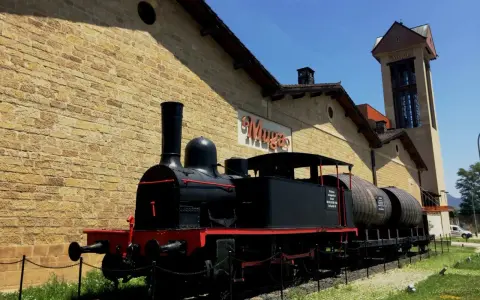 Locomotora antigua frente a las bodegas de Haro, transportando barriles de vino.