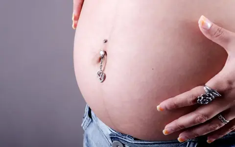 Zakażenie kolczyk w pępku objawia się zaczerwienieniem skóry wokół. Dziecko rośnie, a brzuszek się zaokrągla.