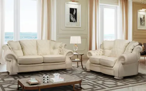 Elegante soggiorno con divani chiari, un tavolino e una lampada. Il tessuto sembra il miglior tessuto per divani antimacchia, ideale per una casa raffinata.
