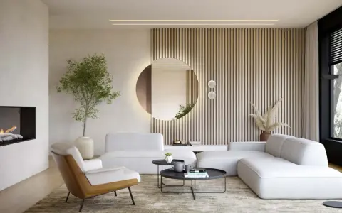 Okrągłe lustro w salonie, podświetlone od tyłu, odbija wnętrze. Obok niego pionowe lamele i nowoczesna sofa.
