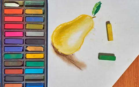 Boîte de pastels secs et une poire dessinée. Apprenez comment faire des pastel en utilisant ces couleurs vives.