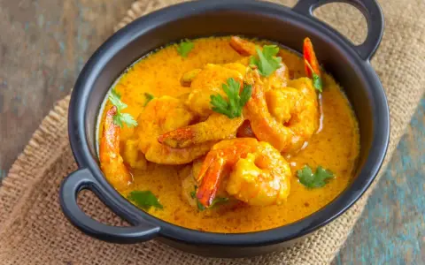 Aksamitny sos curry otula soczyste krewetki, tworząc danie pełne smaku.
