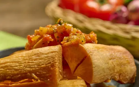 Crujiente yuca frita servida con una sabrosa salsa de tomate y cebolla.