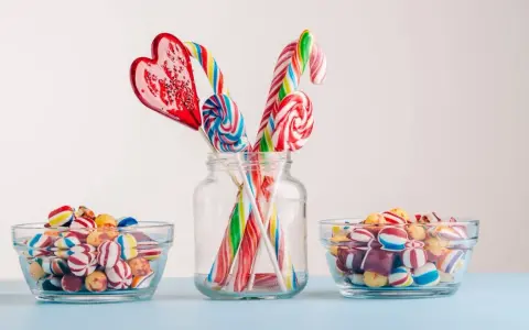 Dulces coloridos y piruletas en forma de corazón y espiral, perfectos para manualidades como regalar chuches.