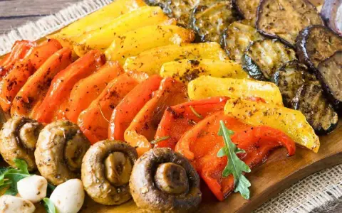 Eine bunte fingerfood antipasti platte mit gegrilltem Gemüse: Paprika, Zucchini, Auberginen und Champignons, appetitlich gewürzt.