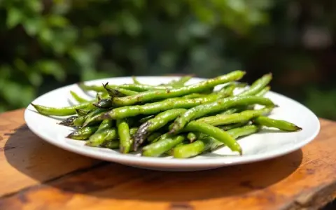 Une assiette de haricots verts grillés, une portion parfaite par personne pour un repas sain et savoureux en extérieur.
