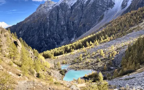Magnifique lac turquoise au cœur d'une vallée alpine aux couleurs d'automne, parfait pour un tour des Écrins 10 jours.