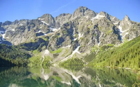 Górskie szczyty odbijają się w tafli Morskiego Oka. To jezioro znajduje się na wysokości 1395 m n.p.m.