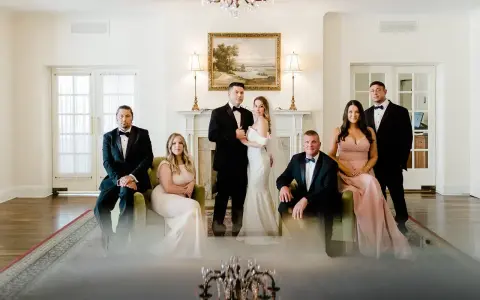 Para ślubna i drużba stoją w eleganckim wnętrzu.