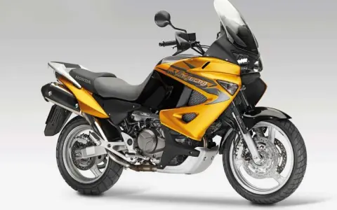 Żółto-czarny motocykl Honda Varadero XL 1000 z dużą szybą, gotowy na dalekie podróże.