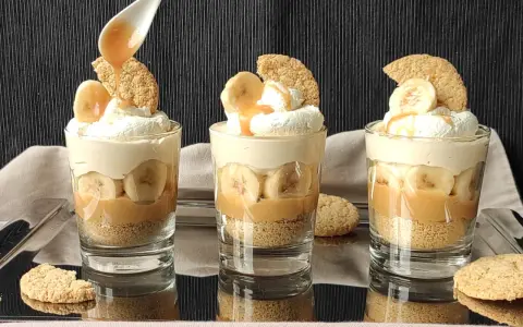 Pyszny deser bananowy przepis w szklaneczkach: warstwy ciastek, karmelu, bananów i bitej śmietany. Idealny na deser!