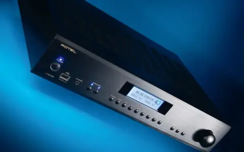 Czarny wzmacniacz Rotel A12 MKII z niebieskim podświetleniem, wyświetlaczem Bluetooth i pokrętłem głośności.