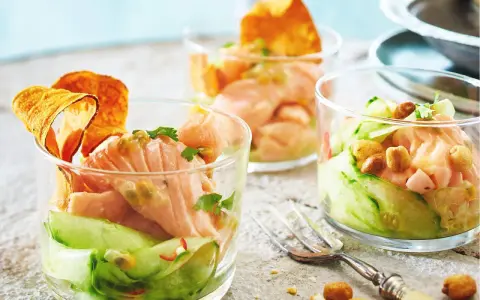 Drei Gläser mit raffinierten Vorspeisen zum Vorbereiten: Lachs-Tatar mit Gurke, Passionsfrucht und knusprigen Chips.